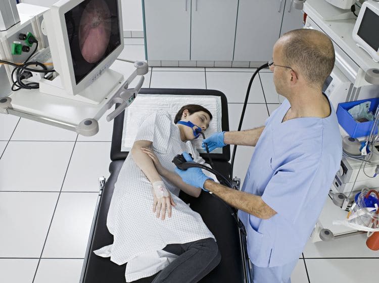 Doctor performing an endoscopy procedure on a patient in a hospital using advanced endoscopic tchnology equipment